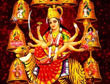 Multi-armed Hindu goddess riding a tiger, surrounded by golden temple bells featuring devotional deity images.