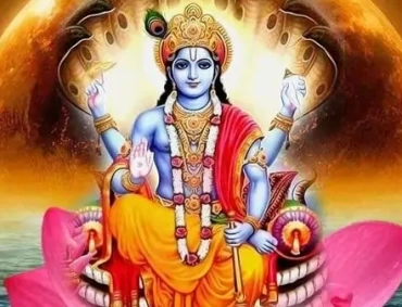 Blue-skinned Vishnu sits on a pink lotus, four-armed, holding conch, discus, mace, blessing hand.
