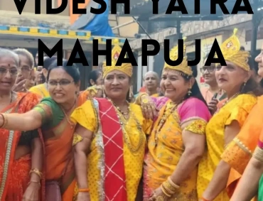 Women in vibrant yellow and orange traditional attire gather smiling during Videsh Yatra Mahapuja celebration.