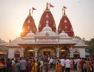 Devotees gathered at Gauri Shankar Mandir in Chandni Chowk, Delhi during evening aarti with the iconic red shikhars glowing at sunset.