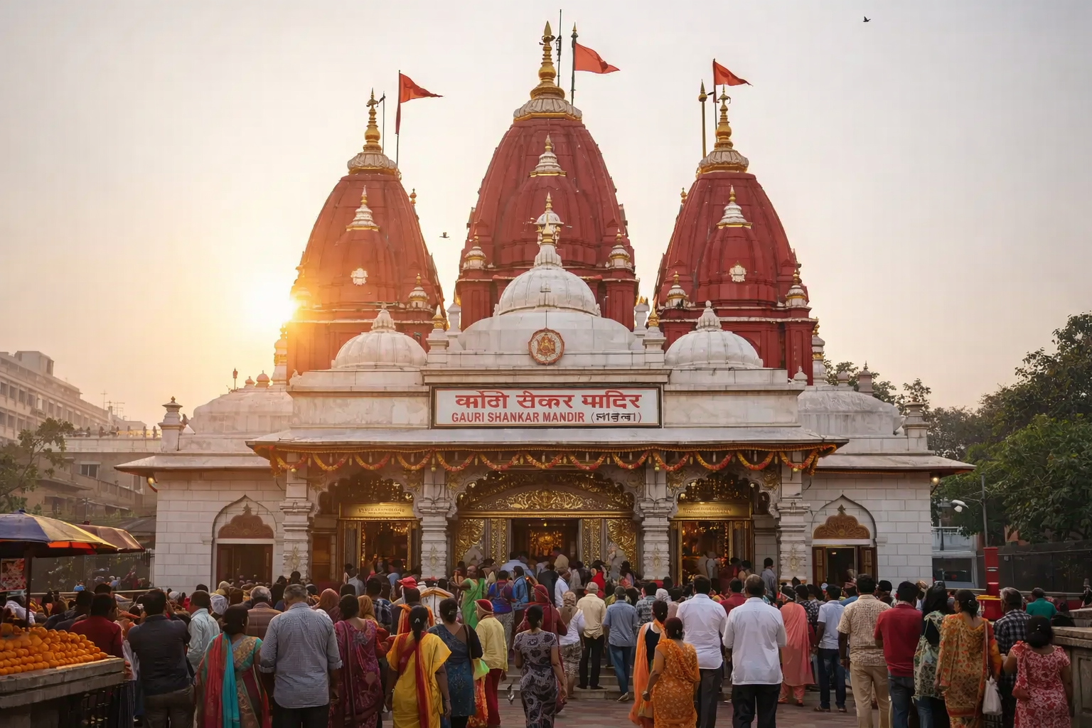 Devotees gathered at Gauri Shankar Mandir in Chandni Chowk, Delhi during evening aarti with the iconic red shikhars glowing at sunset.